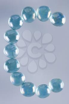 Close-up of marble balls arranged in the shape of letter C