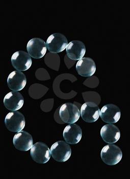 Close-up of marble balls arranged in the shape of letter G