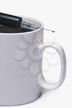 Coffee cup with a syringe