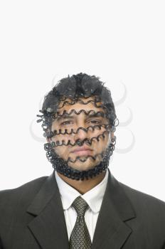 Portrait of a businessman wrapped with telephone cord