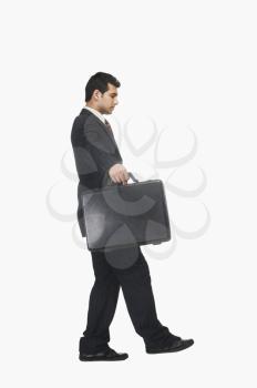 Businessman walking carefully with a briefcase