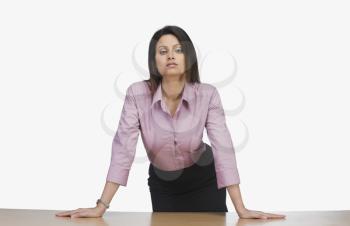 Businesswoman leaning against a desk