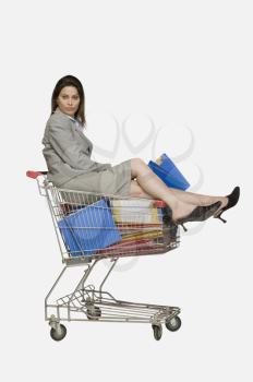 Portrait of a businesswoman sitting in a shopping cart