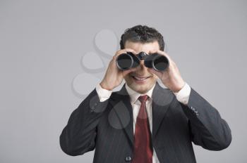 Businessman looking through binoculars