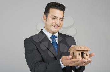 Businessman holding a model home