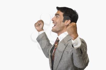 Businessman cheering and clenching fist