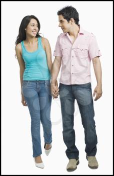 Couple looking at each other and walking with holding hands