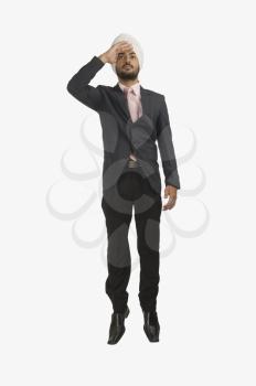 Businessman looking away with shielding his eyes
