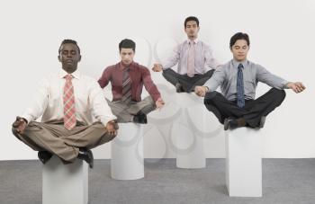 Four businessmen practicing yoga