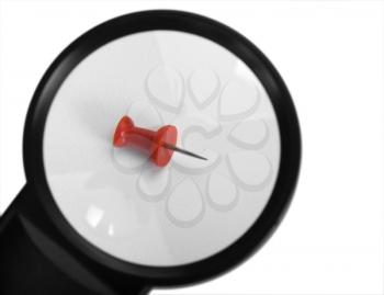 Close-up of a magnifying glass with a thumbtack