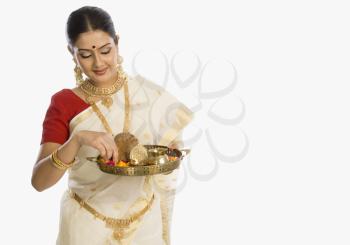 Woman holding a plate of religious offerings