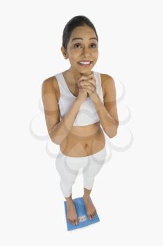 Woman measuring her weight on a weight scale