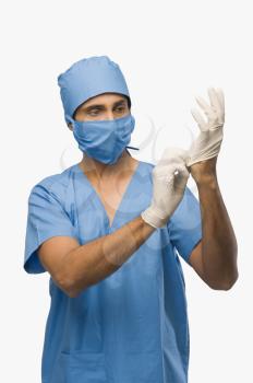 Surgeon putting on surgical gloves