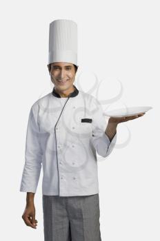 Portrait of a chef holding a plate and smiling