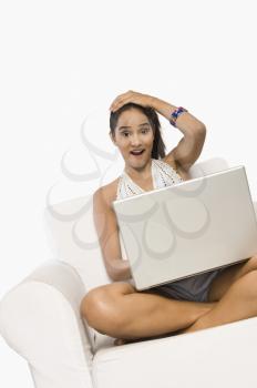 Woman using a laptop and looking surprised