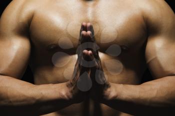 Mid section view of a muscular man meditating