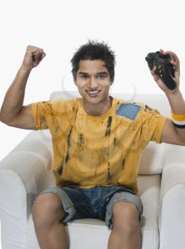 Portrait of a man cheering while playing video game