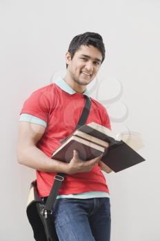 Portrait of a man holding books and smiling