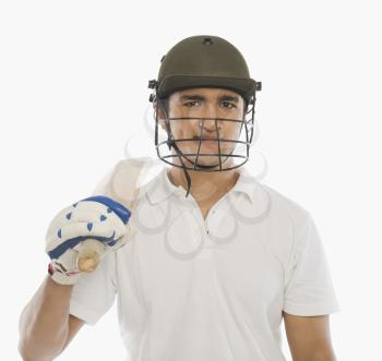 Portrait of a cricket batsman holding a bat and smiling