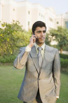 Businessman talking on a mobile phone in a park