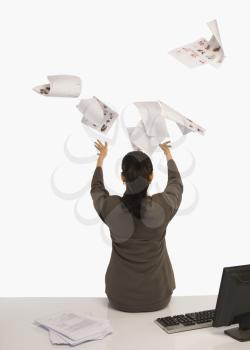 Businesswoman tossing documents in an office