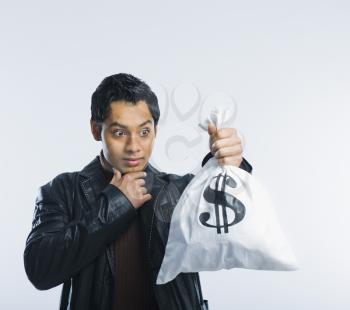 Man holding a money bag and thinking