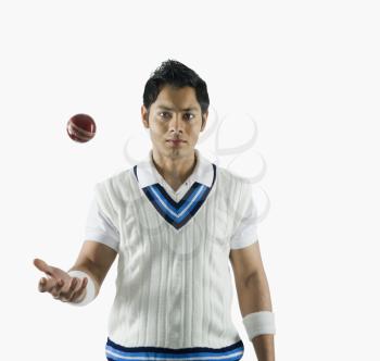 Portrait of a cricket bowler tossing a ball