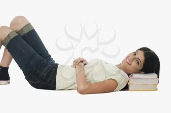 Female university student resting on a stack of books