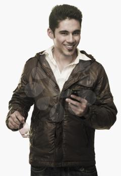 Portrait of a man text messaging on a mobile phone