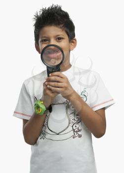 Portrait of a boy holding a magnifying glass and smiling