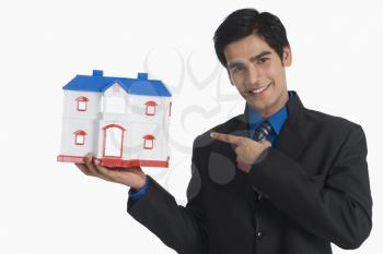 Real estate agent pointing at a model home