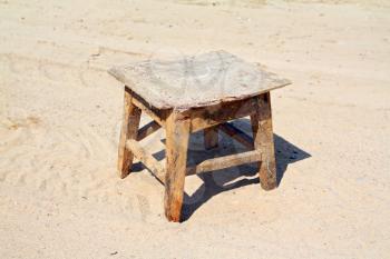 old stool on sandy road