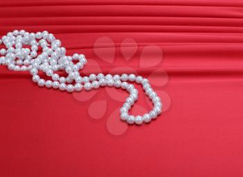 pearls beads on red silk background