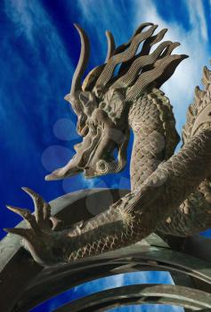 Bronze dragon on the blue sky background
