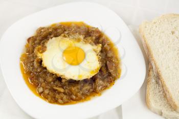 Royalty Free Photo of a Bowl of Stew Topped with an Egg