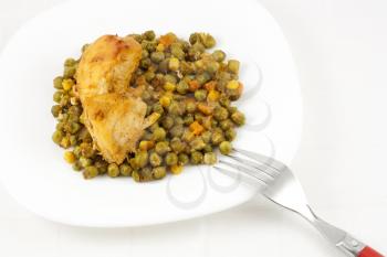 Healthy meal with baked chicken meat, carrots, peas, and corns.