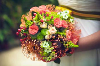 Bride with bouquet from different flowers. Close up