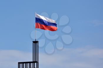 Flag of Russia against the blue sky with wind.