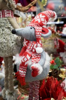 A gray mouse in a red hat and scarf, soft toy for Christmas or New Year 2020