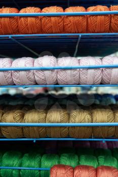 Threads for knitting different colors on the shelf in the store.