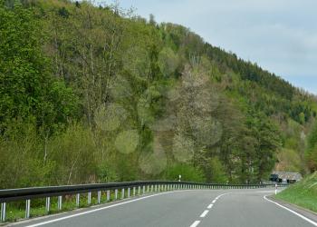 Spring landscape with an asphalt road through a forest in Germany