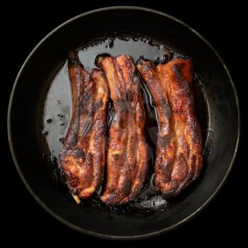 Juicy fried pork ribs in a pan