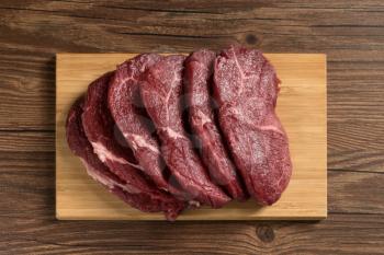 Raw beef with wooden table background, still life photography.
