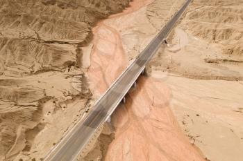 Dryness land with erosion terrain with highway crossing. Photo in western China