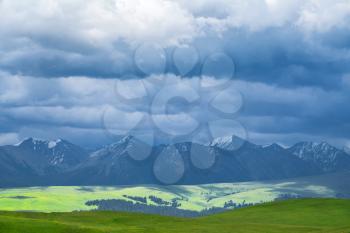 Grassland and mountains in a cloudy day. Shot in Xinjiang, China.