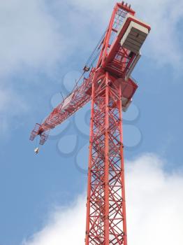 Building crane in a construction site over blue sky