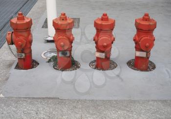 row of fire hydrants on concrete pavement