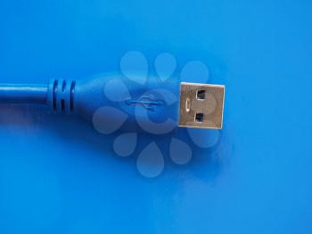 USB plug for computer over blue background