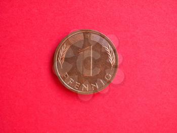 Vintage 1 pfenning coin from Germany over red background