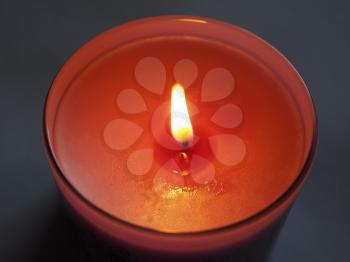 red lit scented candle with flickering flame